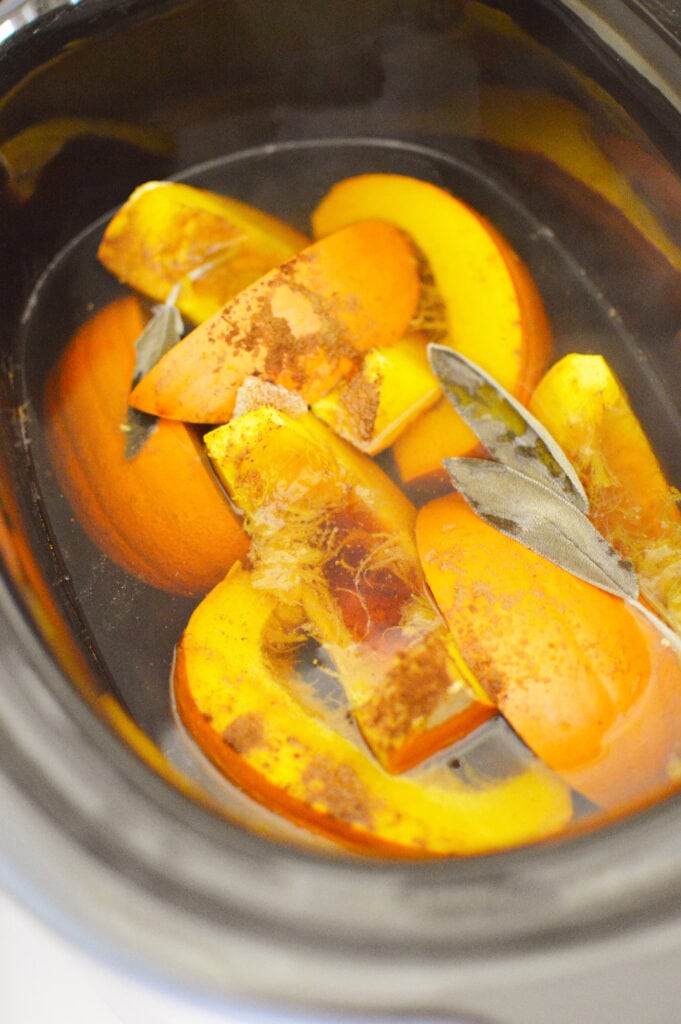 pumpkin pie slices and sage leaves in water in crock pot potpourri