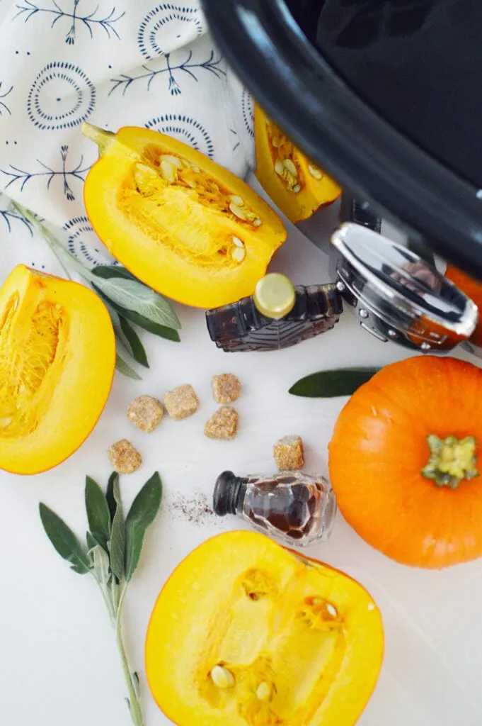 cut pumpkins sage leaves sugar cubes maple syrup next to crock pot for potpourri