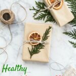 gift wrapped in brown paper with evergreen and dried orange topper