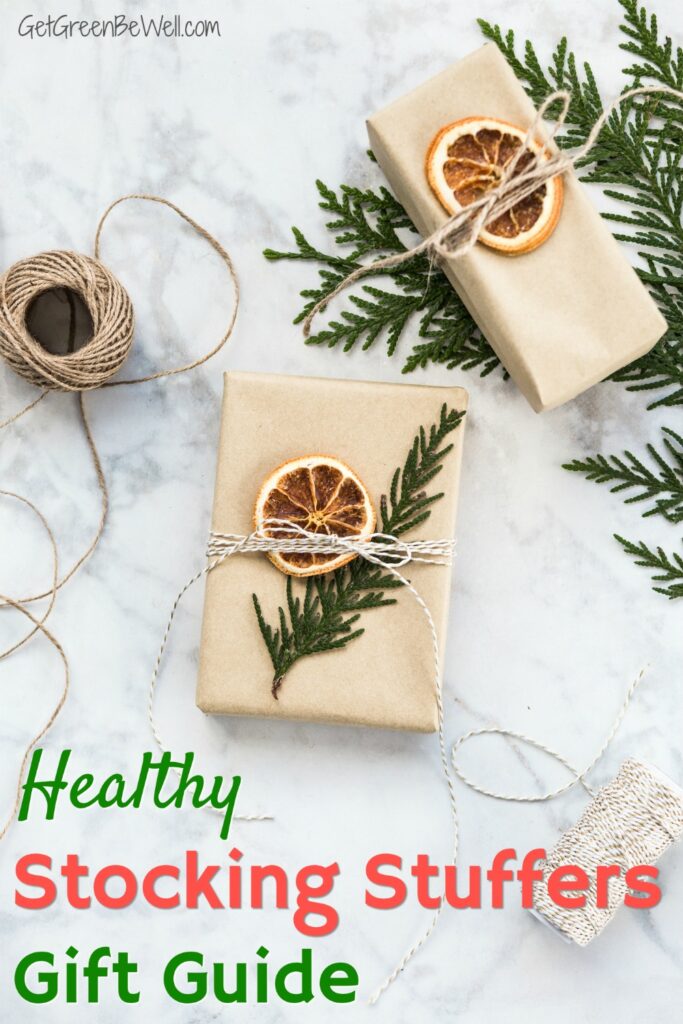 gift wrapped in brown paper with evergreen and dried orange topper