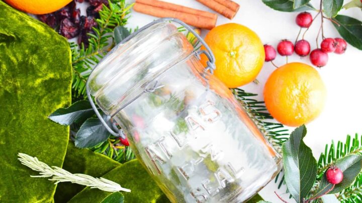 glass jar on crab apple oranges and greenery