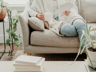 woman sitting on couch reading a book