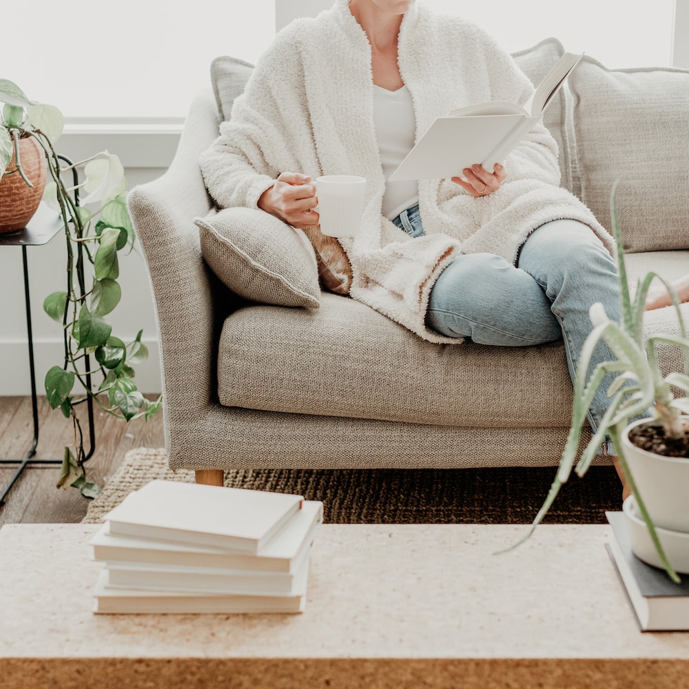 woman sitting on couch reading a book