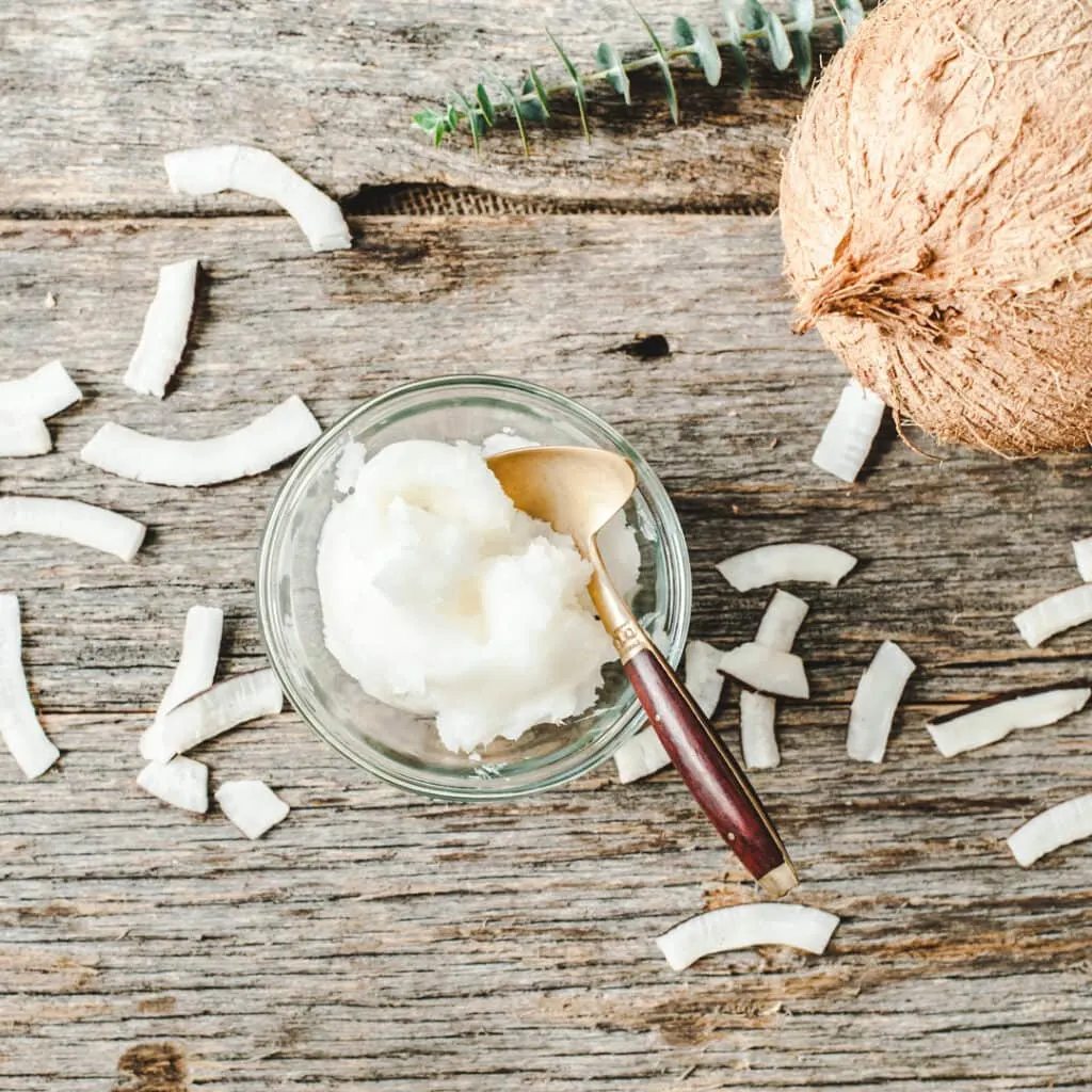 coconut oil in bowl on wood background