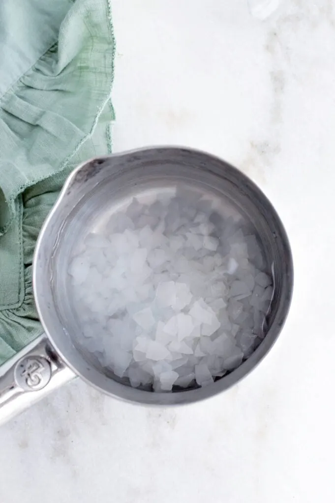 magnesium flakes in stainless steel pot on white marble background