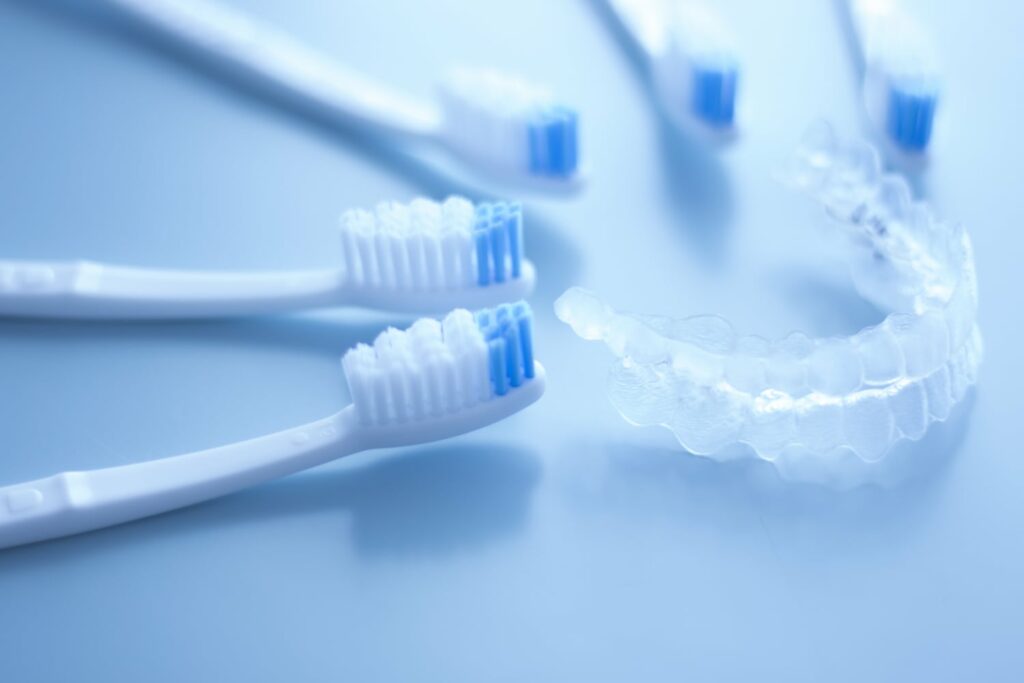 toothbrushes next to retainer on blue background