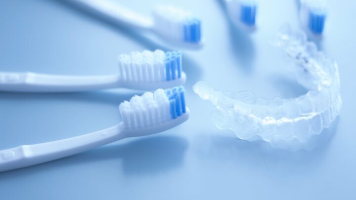 toothbrushes next to retainer on blue background