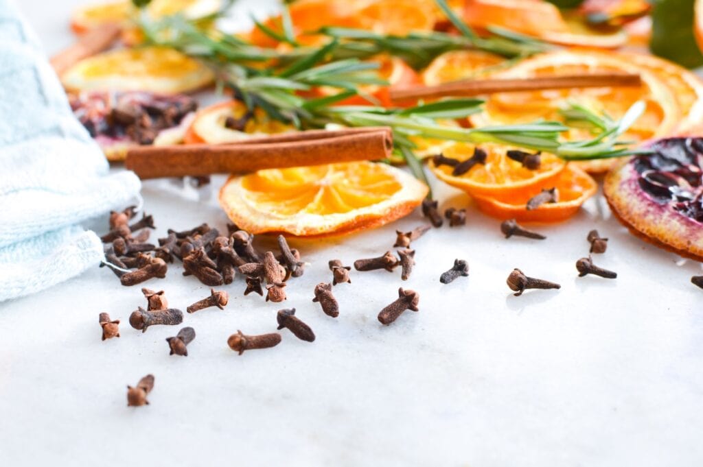 orange slices and cloves on marble table