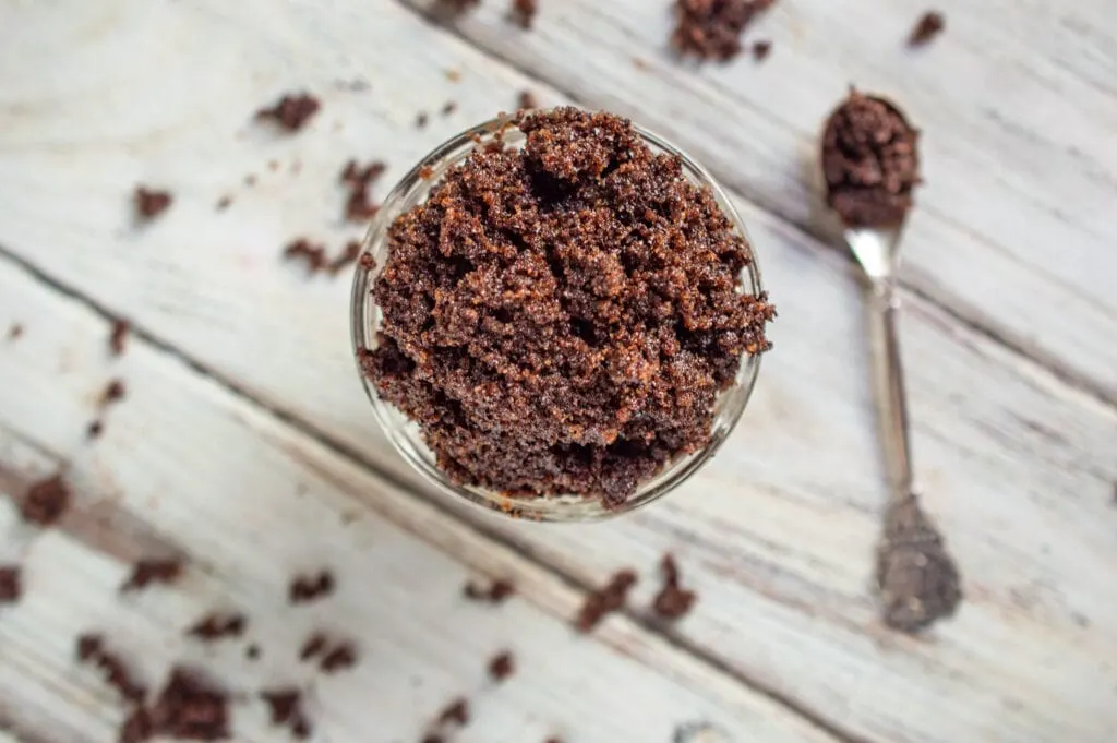 coffee sugar scrub in glass bowl on white wood background