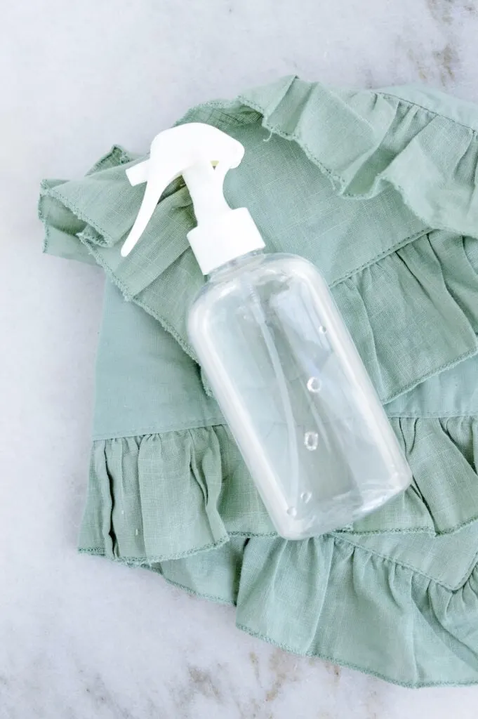 clear glass spray bottle on green towel