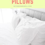 white pillow cases on bed pillows against grey headboard