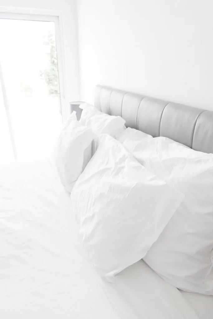white bed pillows on white sheets
