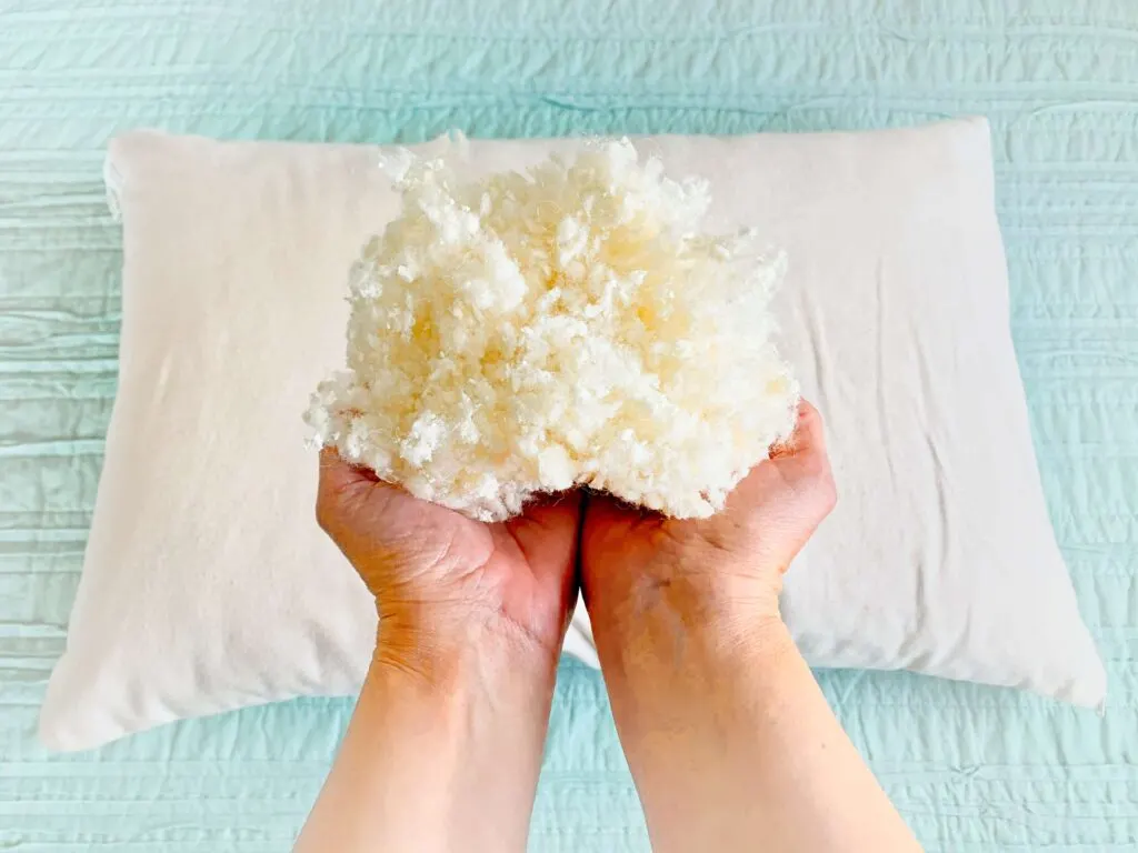 woman holding wool latex fill from customizable pillow