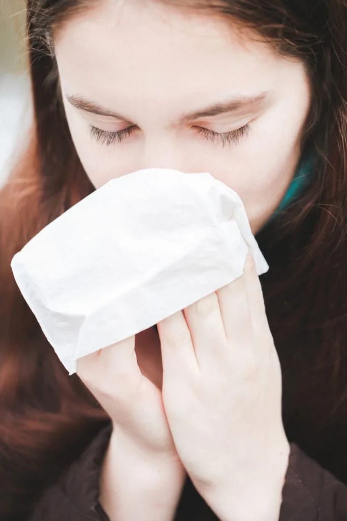 woman sneezing into a cloth