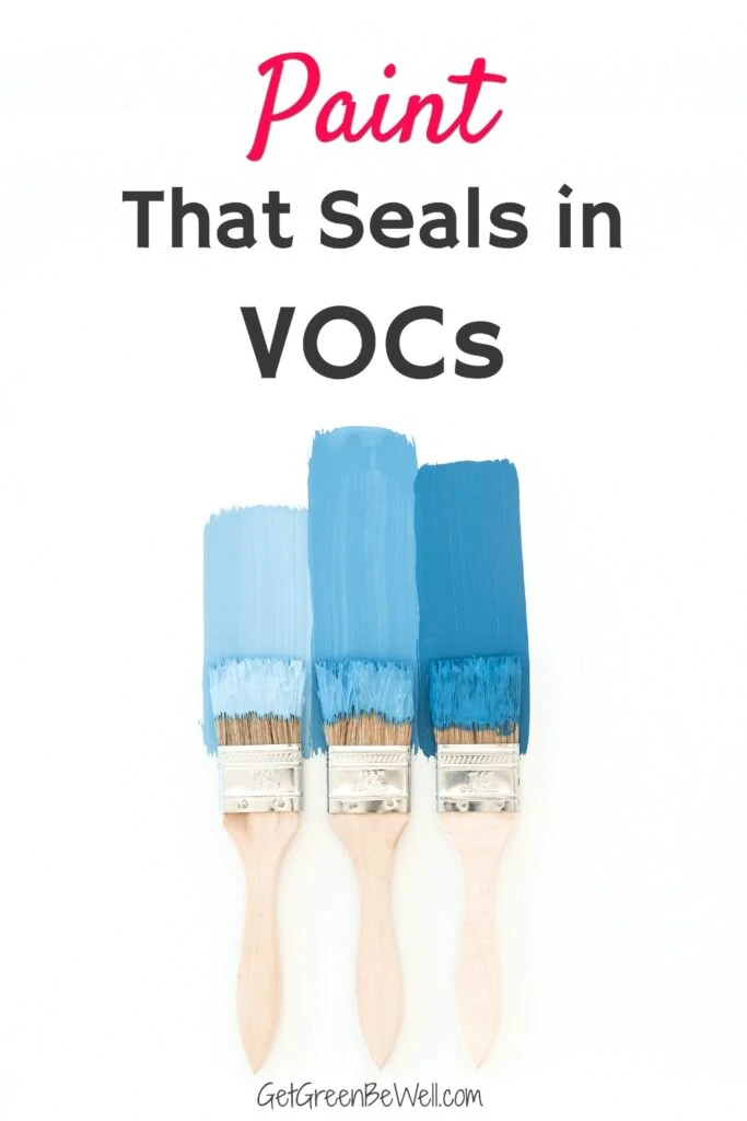 three paint brushes coated in blue paint against white background