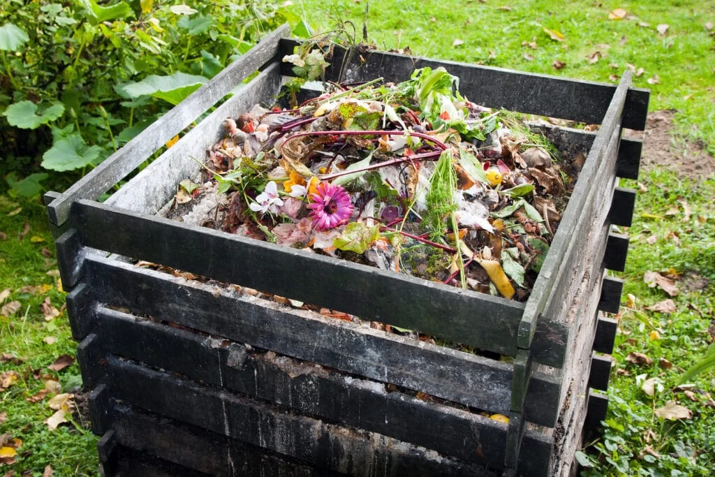 wooden compost bin filled with trash