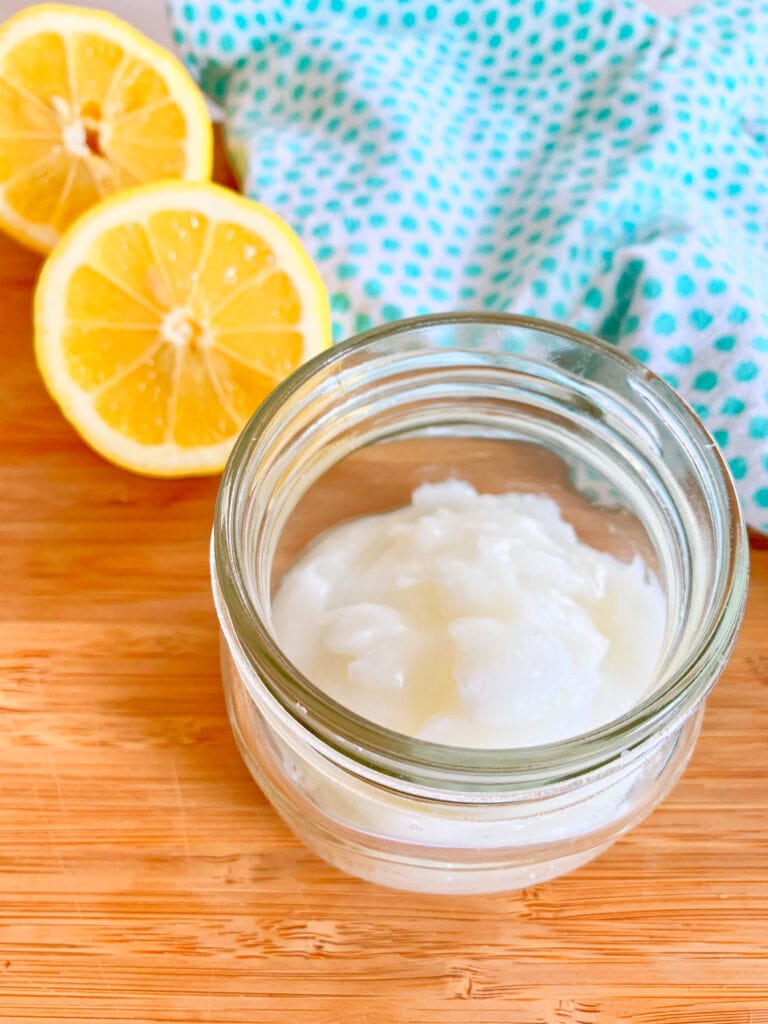 mason jar of white thick gel on next to cut lemons and blue towel