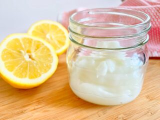 non toxic white gel cleaner in small mason jar next to cut lemons