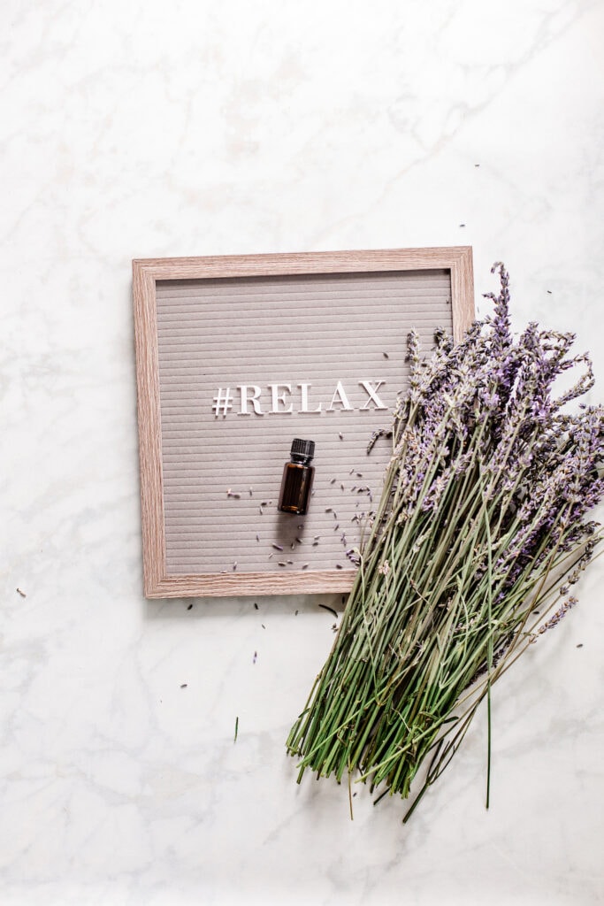 bunch of lavender flowers on top of letter board with word relax