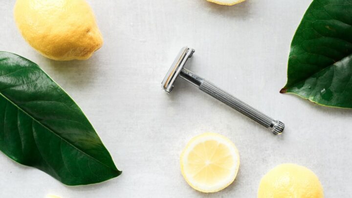lemons and razor on white surface with leaves