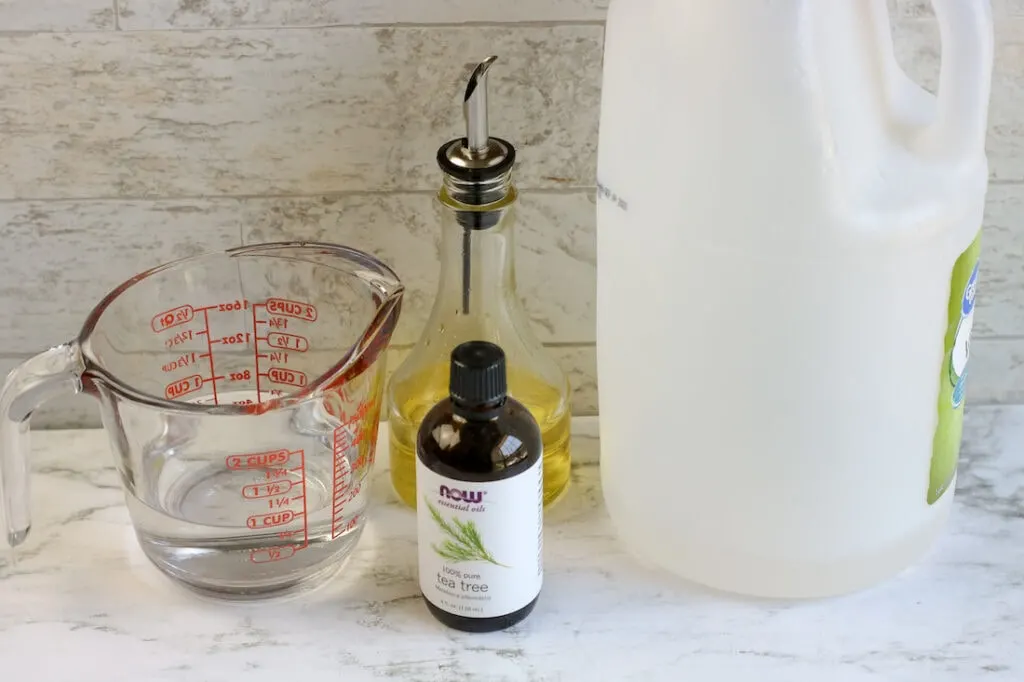 measuring cup olive oil vinegar and essential oil bottle
