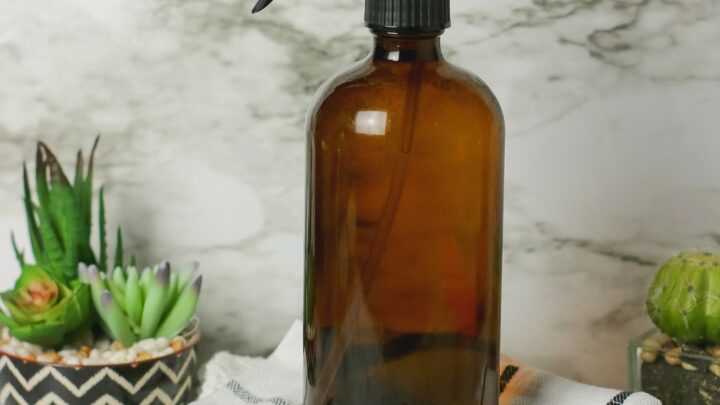 brown spray bottle on top of cleaning rags