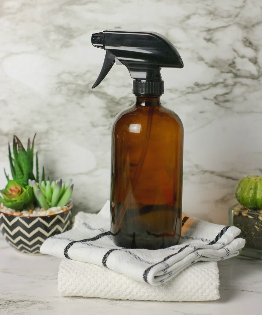 brown glass spray bottle on dusting cloths