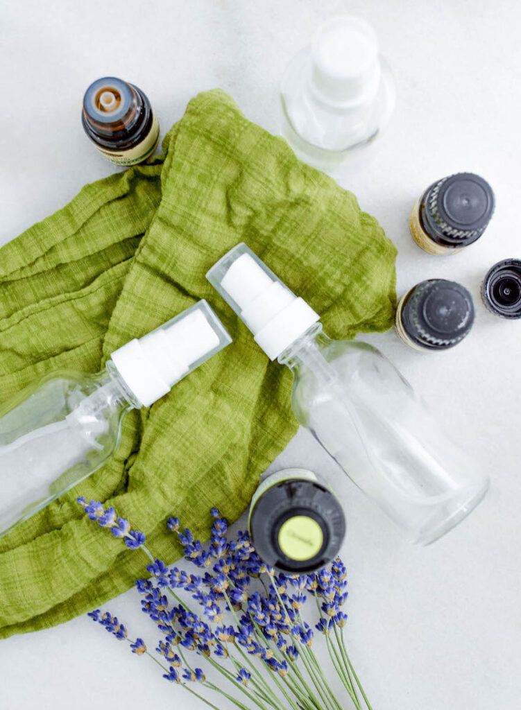 glass bottles and essential oil bottles on green scarf background