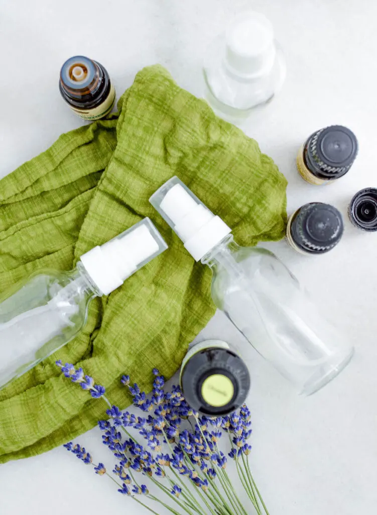 glass bottles and essential oil bottles on green scarf background