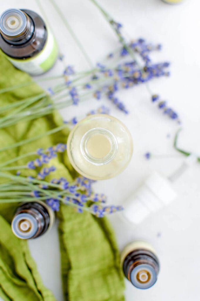 overhead view of glass bottle with essential oils on table