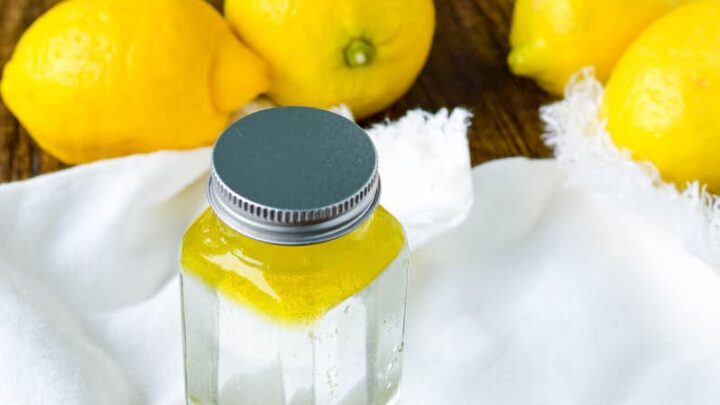 glass bottle filled with vinegar and olive oil sitting on white rag