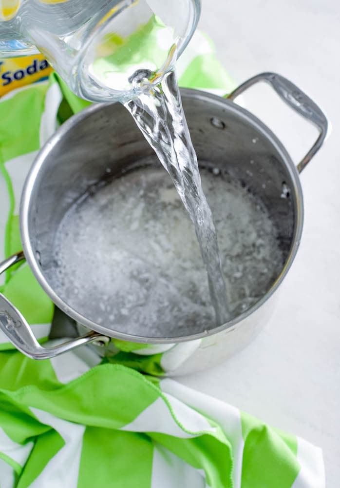 pouring water into a stainless steel pot