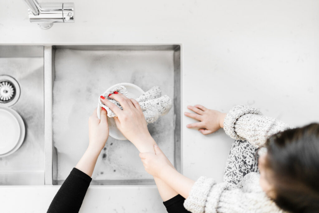 child helping mom wash dishes