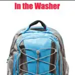 A blue, gray, and black backpack with multiple compartments and a front bungee cord. The text overlay reads "How to Wash a Backpack in the Washer" and the website "GetGreenBeWell.com," providing essential tips on how to wash a backpack properly.