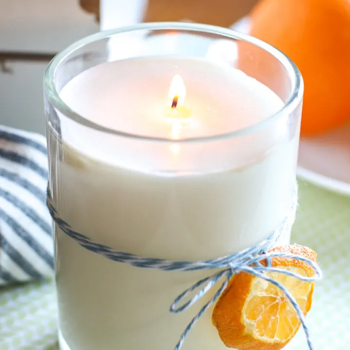 handmade candle with dehydrated orange tied to glass jar
