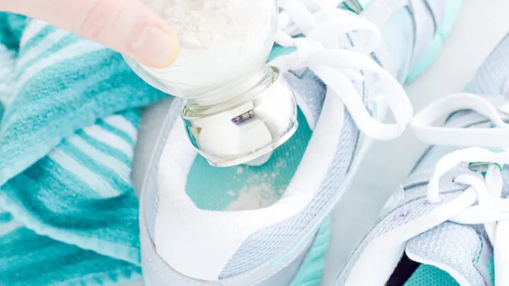 shaking natural foot powder into a smelly shoe