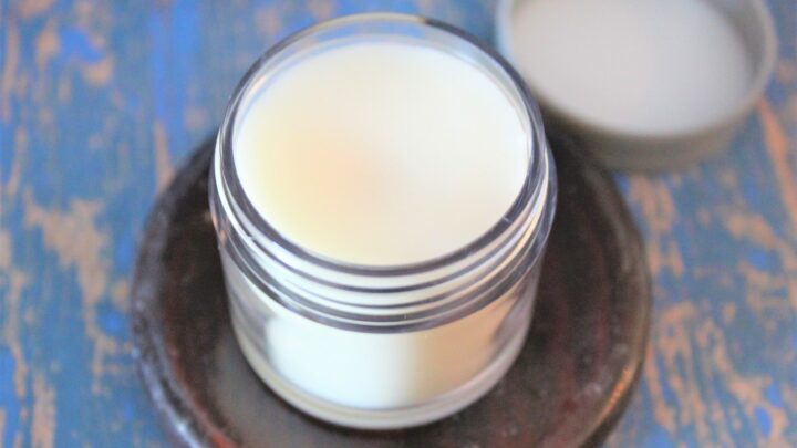 jar of beeswax balm on blue background