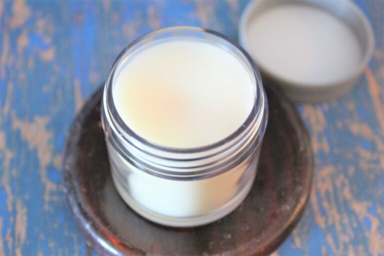 jar of beeswax balm on blue background