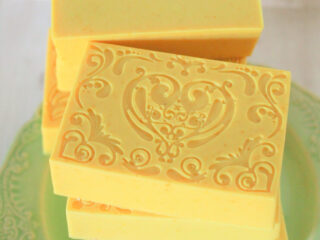 yellow turmeric soap bars stacked on green plate