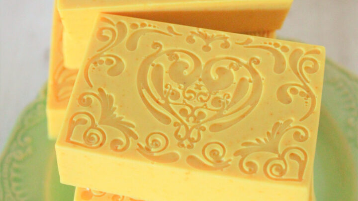 yellow turmeric soap bars stacked on green plate