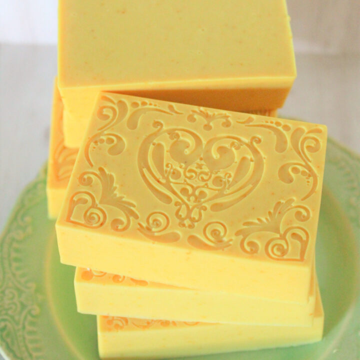 yellow turmeric soap bars stacked on green plate