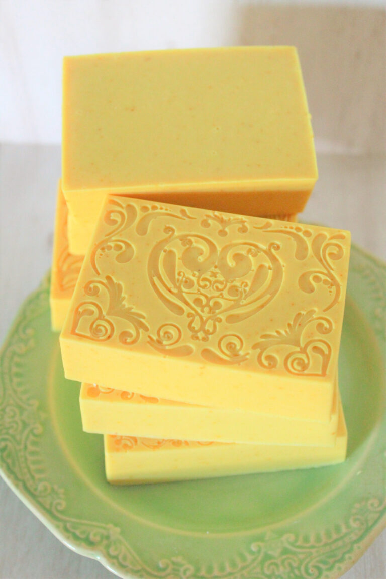 yellow turmeric soap bars stacked on green plate