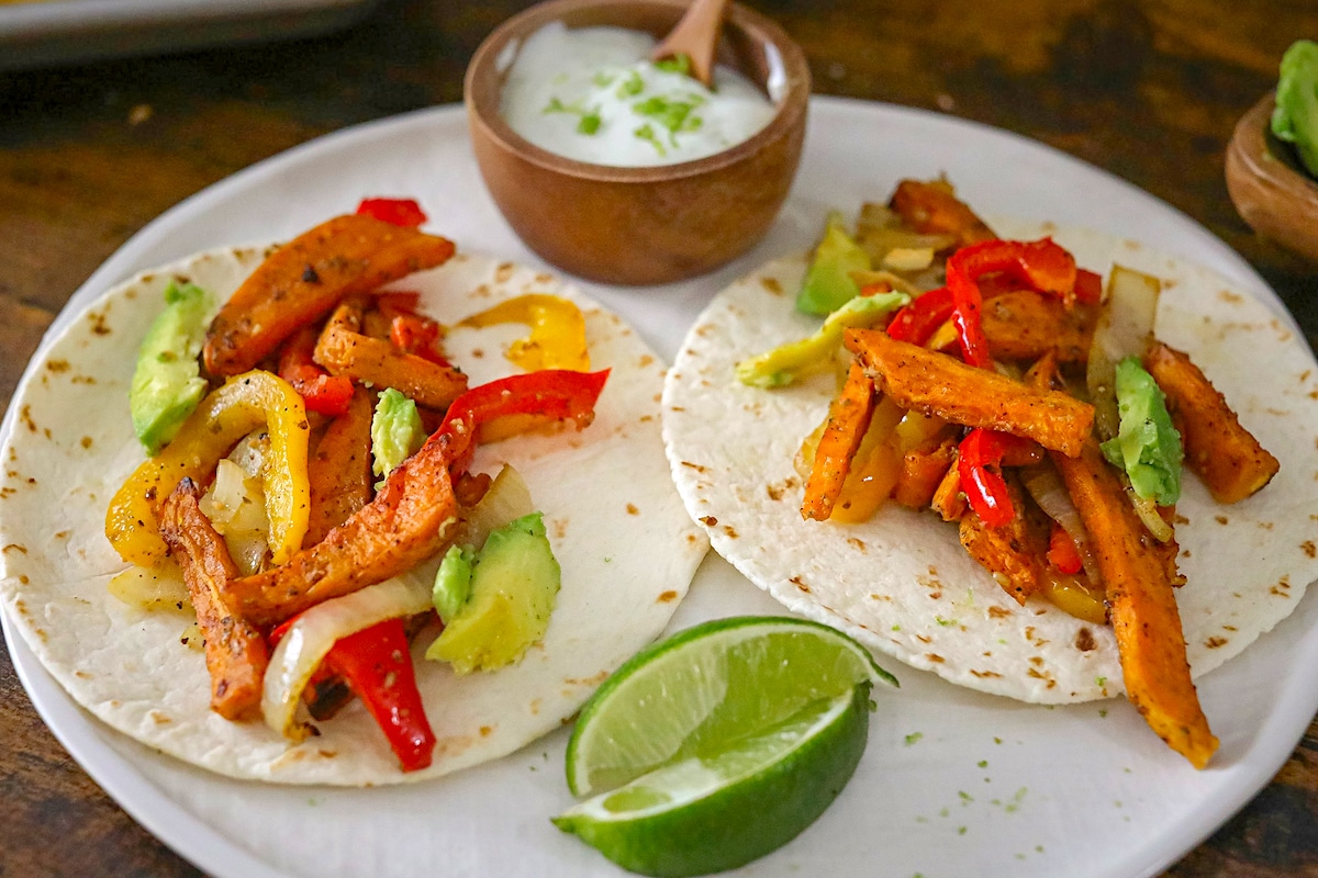 Sweet Potato Fajitas on a white plate with a wedge of lime