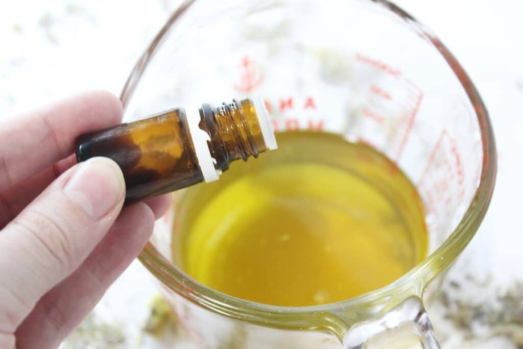 Cramp Cream Step 3 with a hand holding a bottle of essential oil.