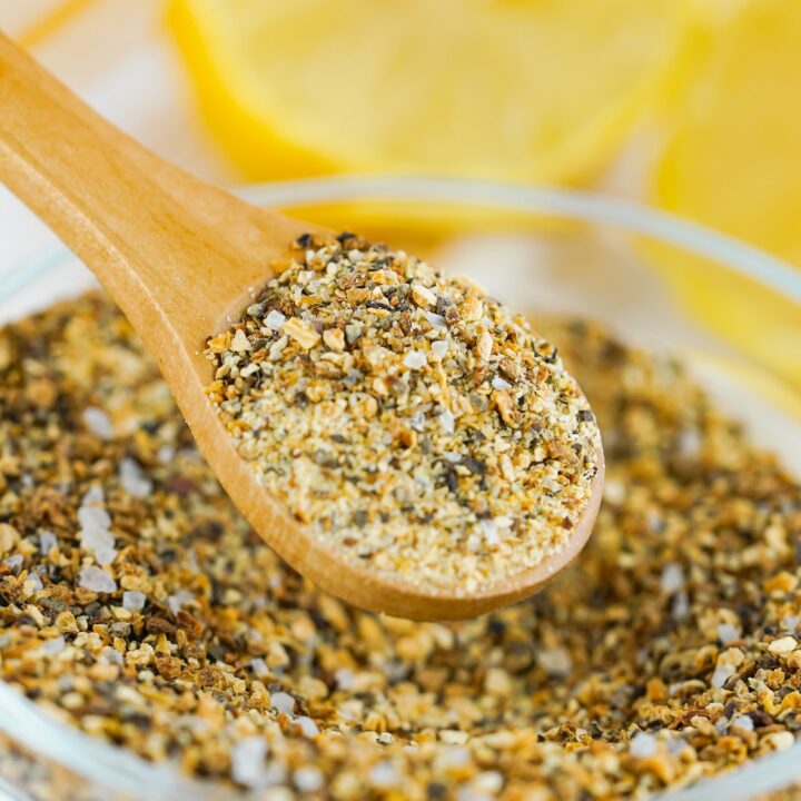 A glass bowl filled with homemade lemon pepper seasoning.
