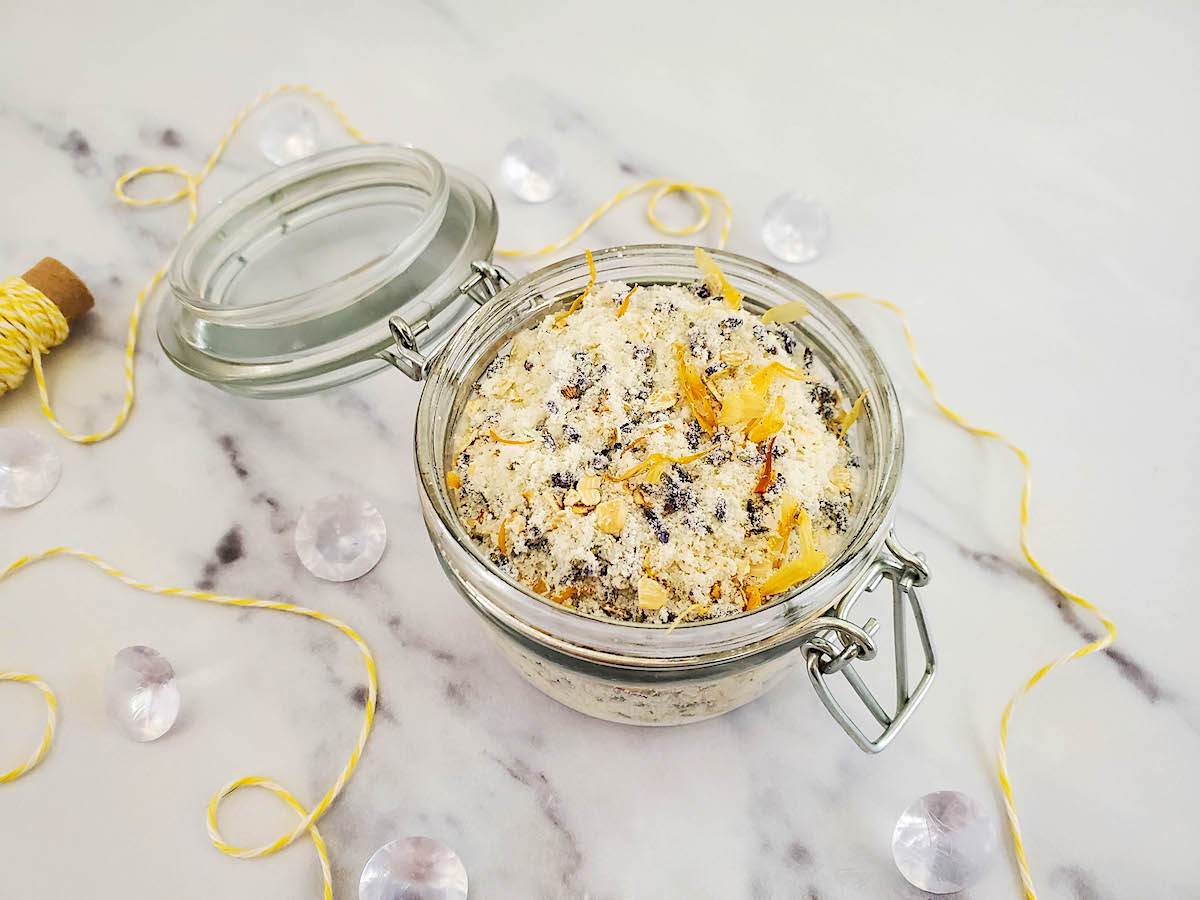 DIY Oatmeal Milk Bath mixture in a glass jar on a white marble table.