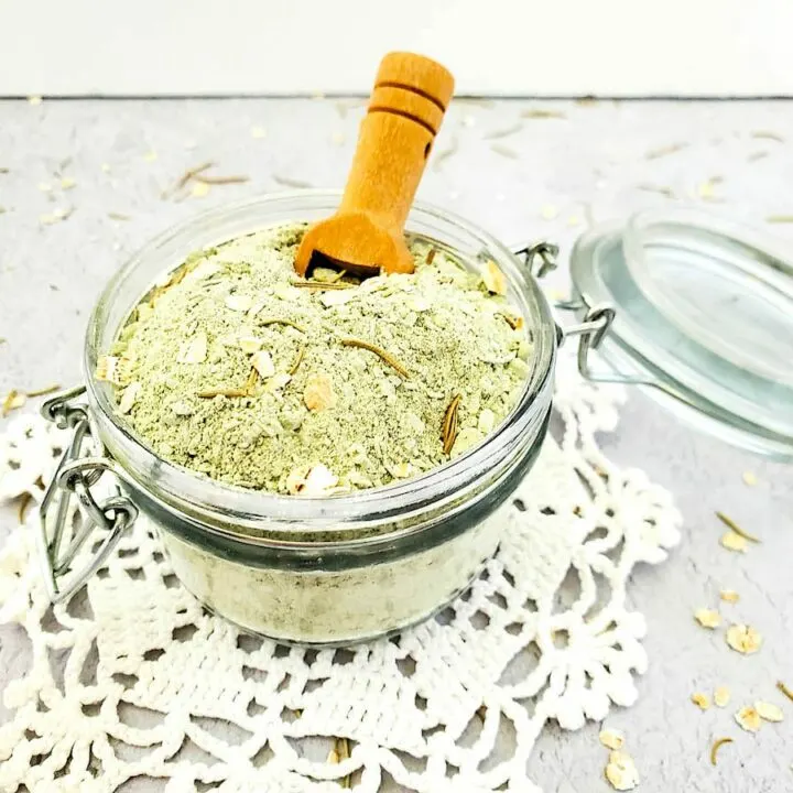 A jar filled with a Detox Clay Bath mixture and a wooden spoon.