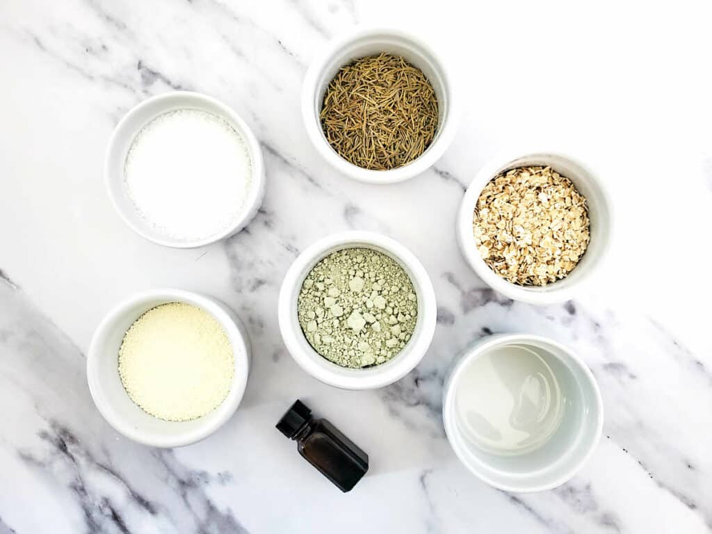 Five bowls of Detox Clay Bath ingredients on a marble countertop.