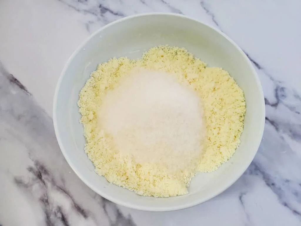A bowl filled with a mixture of flour and sugar for a milk and honey floral bath soak.