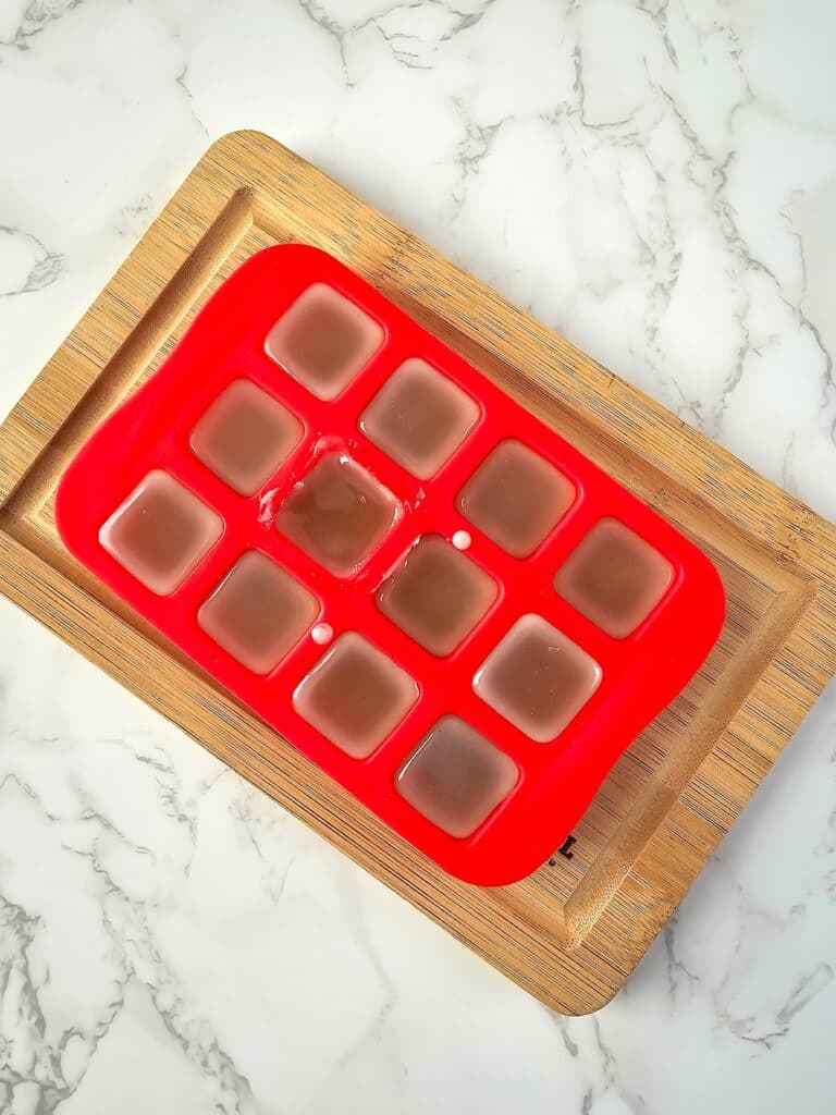 Vanilla Homemade Lotion Bar Step 5 - A red tray with ice cubes on it.